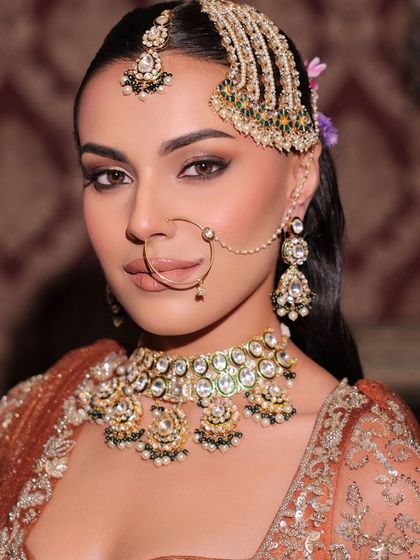 A close-up showcasing the artistry of a modern bridal look. Notice the defined, smokey eyes and the unique passa jewellery, all balanced with a soft, neutral lip colour.