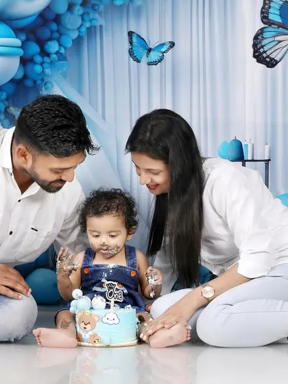 A cake smash is always more fun with family. This shot captures the happy chaos as Naksha explores his first birthday cake with his parents. I love getting these interactive family photos that show the love and connection during the celebration.