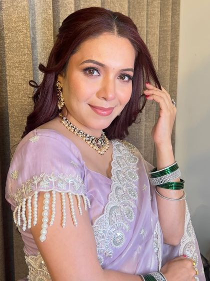 A direct portrait of Ashwini, showcasing the flawless base and soft pink tones used in her makeup.