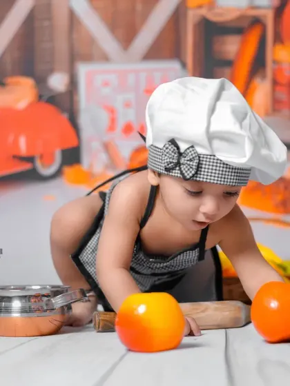 Getting hands-on with the cooking tools. I encourage babies to play freely, which allows me to capture their natural curiosity during these milestone photography sessions.