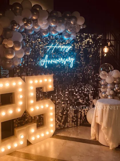 Another view of the 25th anniversary decor, showcasing the 'Happy Anniversary' neon sign and the confetti-filled bubble balloon.