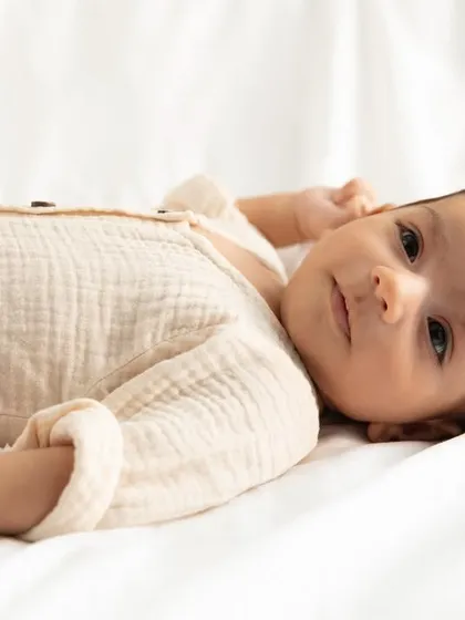 Lying peacefully on a soft white blanket, this baby looks directly at the camera. I love capturing these moments of quiet connection.