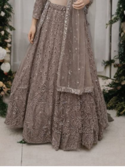 A detailed shot of the lehenga skirt, showing the intricate floral and geometric handwork that covers the fabric.