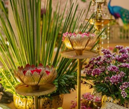 A beautiful arrangement of brass lotus lamps and fresh flowers. These small details, placed strategically around the venue, contribute to the overall sacred and traditional feel of the wedding.