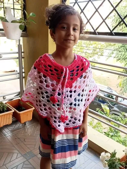 Another happy little customer wearing the pink and white crochet poncho.