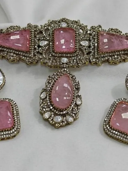 A unique choker set with large pink stones and Polki detailing. This statement piece is available for rent and is perfect for making an impression at any party.