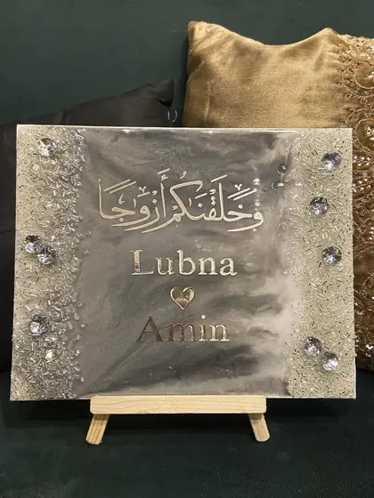 A unique and heartfelt gift for a special couple. This handmade resin plaque features the couple's names and a Quranic verse in a beautiful silver and grey marble design, wishing them a lifetime of love and togetherness.