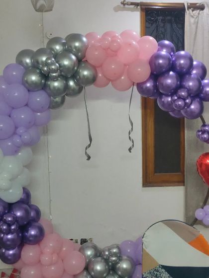 A half-arch balloon ring in purple, pink, and silver, perfect for smaller spaces or as a simple photo corner.