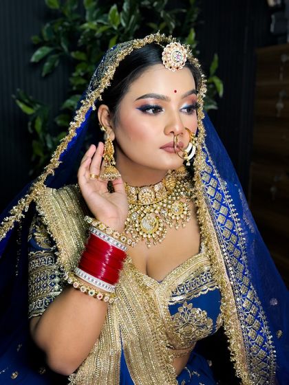 A classic portrait of the Rajputi bride, looking elegant and regal in her blue and gold attire.