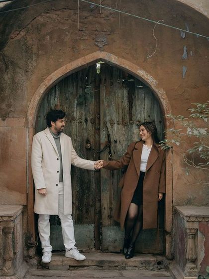 A classic pose in front of a rustic, old-world door in Delhi. This shot blends vintage charm with the couple's modern style for a unique pre-wedding portrait.