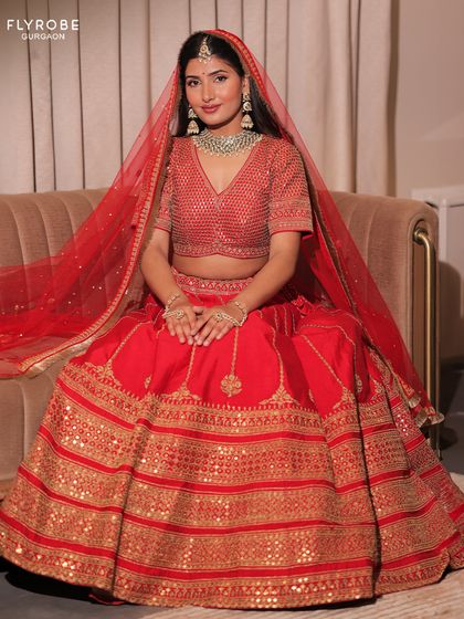 Here is the full view of the classic red bridal lehenga. The flowing A-line skirt and matching sheer dupatta create a look that is both traditional and breathtakingly beautiful.
