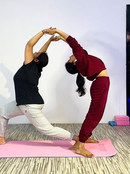 Creating shapes and building connections. This partner pose forms a beautiful arch, demonstrating how two people can work together to deepen their backbends and support each other's practice.