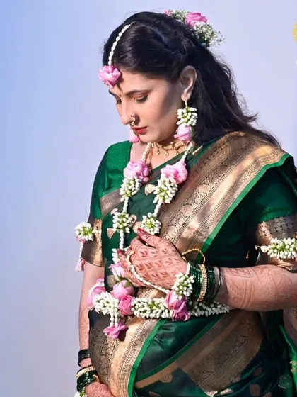 A serene moment during a maternity shoot. This mom-to-be is wearing a delicate pink and white floral set that beautifully accentuates her green saree and the joy of this special time.