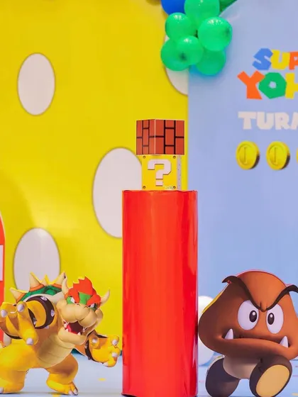 A close-up of the Super Mario decor, featuring character cutouts of Bowser and a Goomba. The bright colors and dynamic poses of the characters add energy to the party setup.