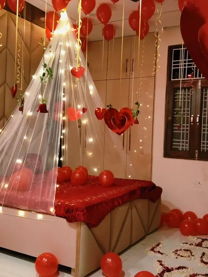 A full view of the romantic room, showing the bed canopy, hanging hearts, and petal messages on the floor. This is a complete package for a memorable surprise.