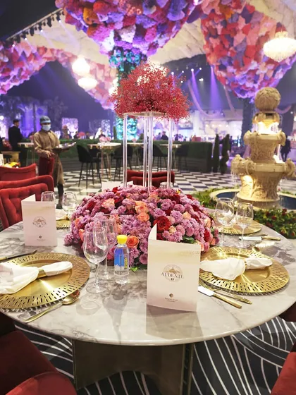 A table setting that exudes pure opulence. With marble tabletops, gold-plated cutlery, and rich red floral centerpieces, we craft a regal dining experience.