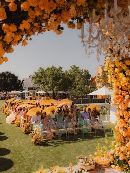 A stunning shot of the wedding ceremony, where the decor perfectly mirrors the floral themes from the invitations. The arch of orange flowers creates a breathtaking focal point.