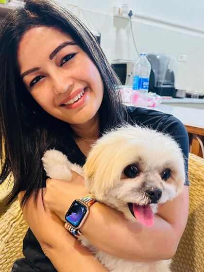 A happy customer smiling with her adorable dog. This photo is part of a 5-star review praising our immaculate facilities and loving staff.