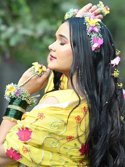 A side profile of a Haldi look, showing the beautiful floral hair accessories and the soft curls in her hair.