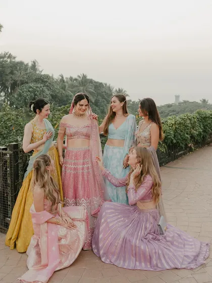 A beautiful, relaxed portrait of the bride with her bridesmaids. Their coordinated outfits and genuine smiles create a lovely image of friendship and celebration.