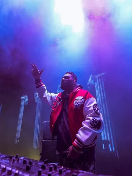 A dramatic shot with purple smoke and lights, capturing the epic atmosphere of a mainstage festival performance.