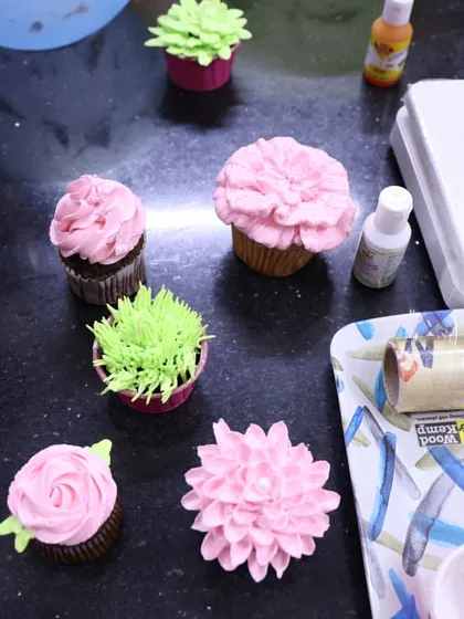 A view of my workstation during a cupcake workshop. You can see various floral and succulent-style cupcake designs, along with the tools of the trade.