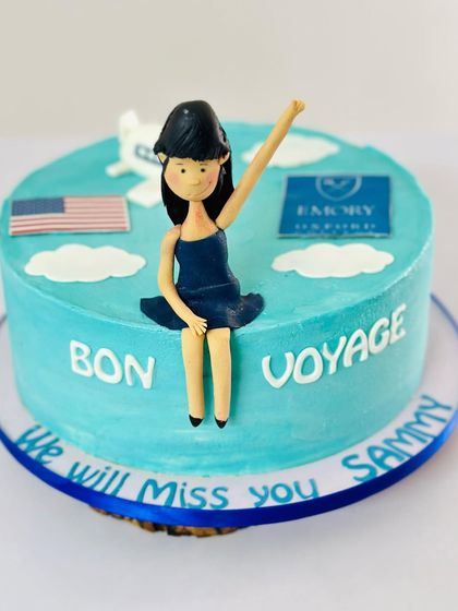 The full "Bon Voyage" cake, celebrating a new beginning at university. The design includes the US flag, the university logo, and a little airplane, all edible.
