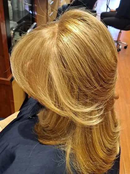 A three-quarter view of the layered blowout, highlighting the smooth, polished finish and the way the layers frame the face.
