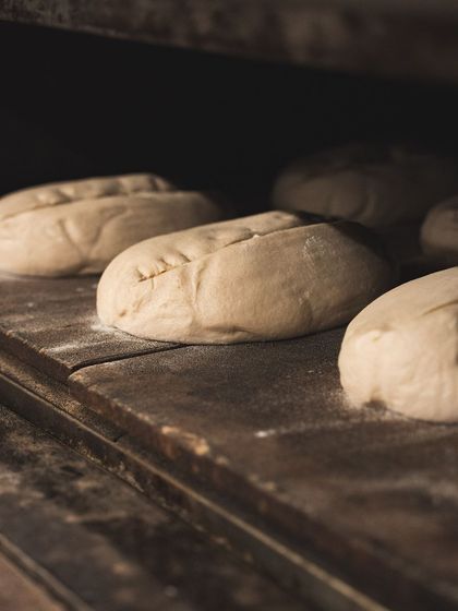 Sourdough loaves scored and ready inside the oven, just before the door is closed for baking.