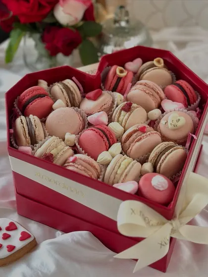 Celebrate love with our luxurious heart-shaped macaron box. It's filled with an assortment of delicate, handcrafted macarons in romantic hues of pink and red.