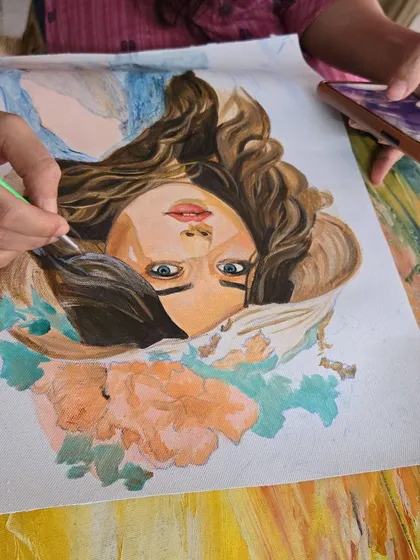 A student carefully adding detail to a portrait, learning how to capture facial features and hair texture with fine brushwork.