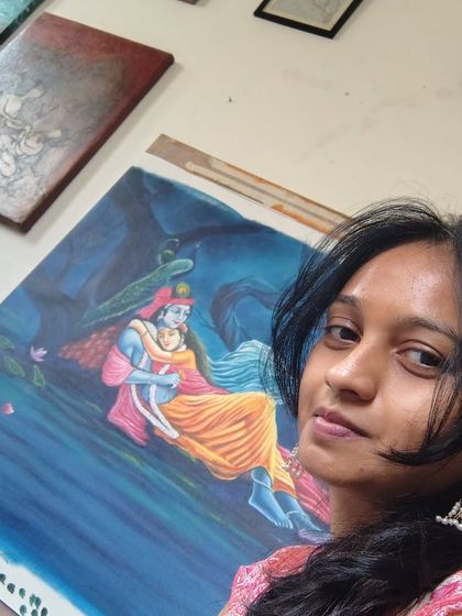 An angled shot showing the Radha Krishna painting on my easel. You can see some of my other smaller works and sketches in the background.