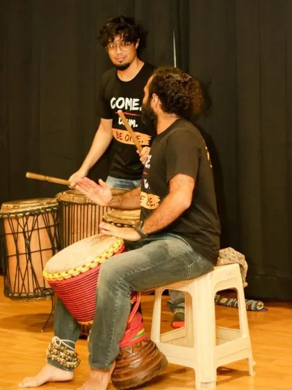 A moment of teaching and connection during an ensemble practice. The student on the Dunun (bass drums) and me on the djembe, finding the groove together.