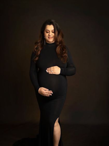 A classic three-quarter portrait in a simple black gown. This pose is elegant, timeless, and beautifully showcases the baby bump.
