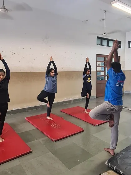 A coach guides young athletes through the tree pose. This shows how we integrate wellness practices directly into our coaching.