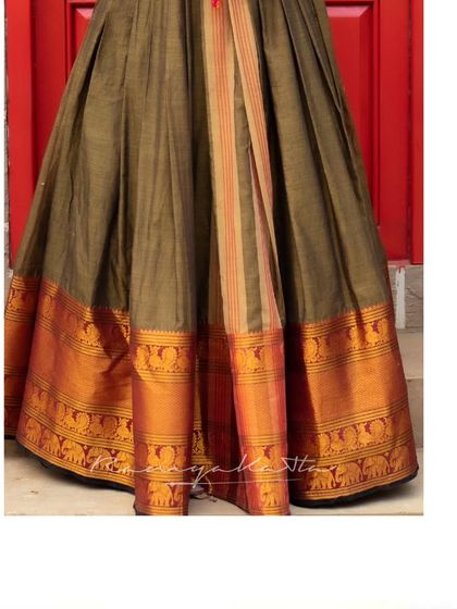 The hem of the caramel brown dress showcases the traditional woven border, grounding the outfit in Indian heritage.