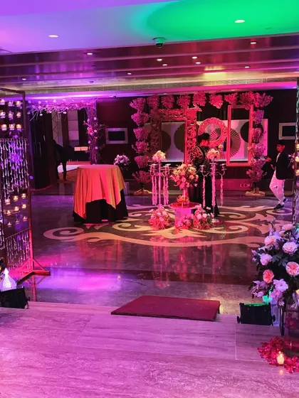 We make sure the wow factor starts the moment your guests arrive. This dramatic entrance uses walls of candles and lush floral arrangements with colorful mood lighting to set a glamorous tone for an indoor reception or sangeet.