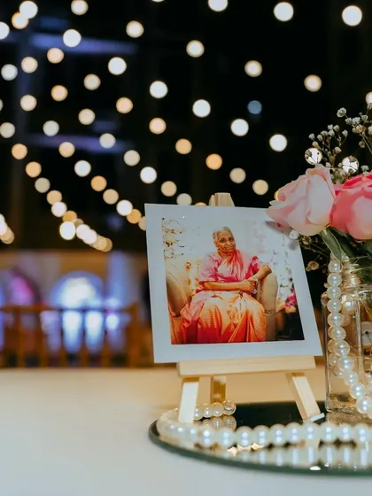 A personal touch on every table. We placed cherished photos of the birthday lady amidst fresh flowers and pearls, adding a layer of personal history and warmth to the decor.