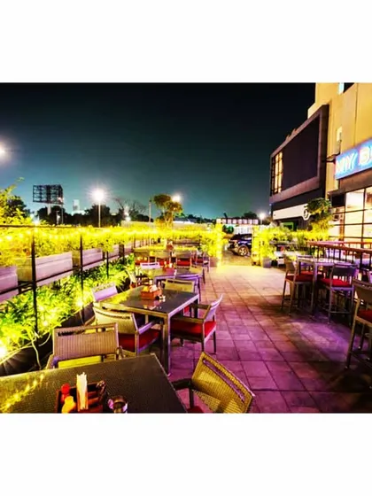 The outdoor terrace at My Bar Headquarters at night. We integrated lighting within the planters to illuminate the foliage, ensuring the space remains inviting and vibrant for the evening crowd.
