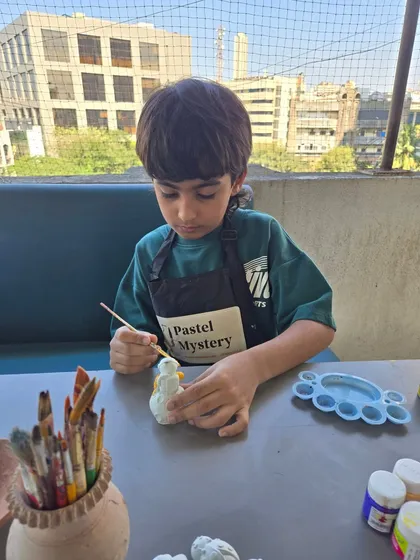 The details make the difference. After the main shaping is done, kids can add their personal touch by painting their pieces. Here, a young artist is carefully painting a small, hand-built sculpture.