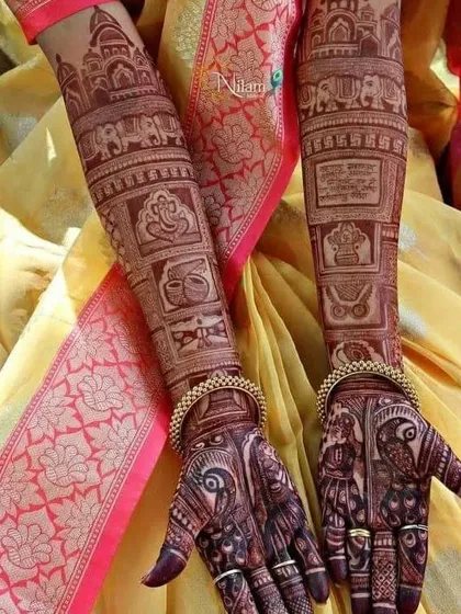 This full arm design is a gallery of auspicious symbols, including Lord Ganesha, elephants, wedding rituals, and temple architecture, telling a story from wrist to elbow.