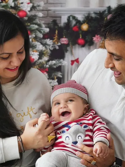 A baby's laughter is the best sound. This family is having a wonderful time during their Christmas session, creating a joyful and authentic portrait.