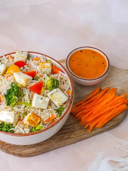 A vegetarian-friendly paneer and vegetable rice bowl, with vibrant bell peppers and broccoli. The bright lighting and simple presentation make the ingredients look fresh and inviting.