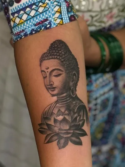 A full view of the finished Buddha and lotus forearm tattoo. The placement flows naturally with the arm's shape.