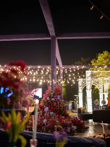Another view of the event space, showing the massive floral installations and the glowing arches in the distance. The string lights above tied the entire outdoor area together.