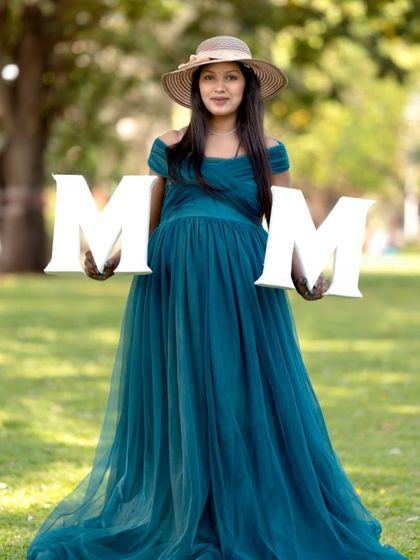 A fun way to announce you're becoming a mom. This client used "MOM" props with our teal gown for a creative and personal maternity photo.
