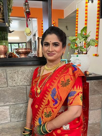 A classic look for a *Munj* (threading ceremony). The client looks elegant and ready for the family function in her beautiful red Paithani saree.