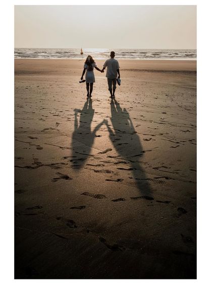 Walking into the sunset, their shadows stretch out before them. This is a powerful and romantic image about walking into a new life together.