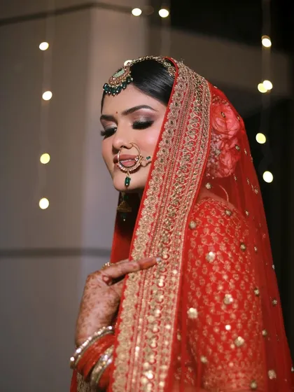 A serene and elegant portrait of the bride. The side profile highlights the flawless eye makeup and the intricate details of her dupatta and jewelry.