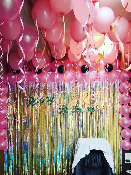 An office birthday celebration made special with a full decorative setup. I used pink balloons for the ceiling and pillars, paired with a shimmering foil curtain to create a festive photo corner and make the team member feel valued.